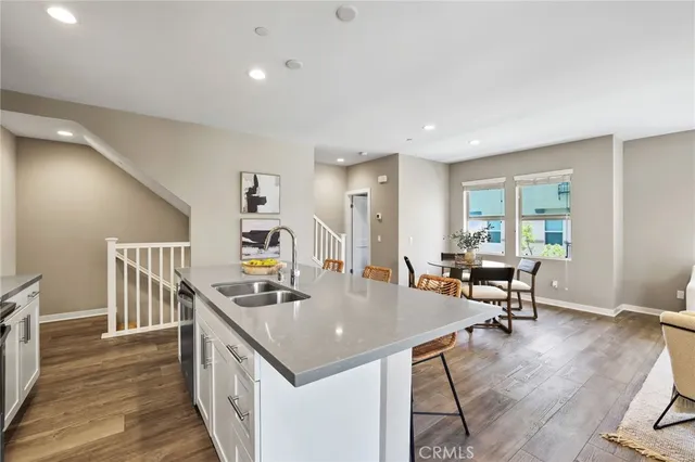 a room with stainless steel appliances granite countertop a table chairs and a refrigerator