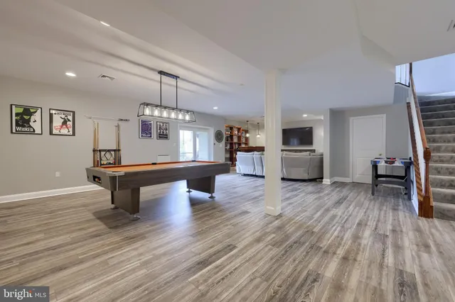 an aerial view of a house with yard and trees in the background