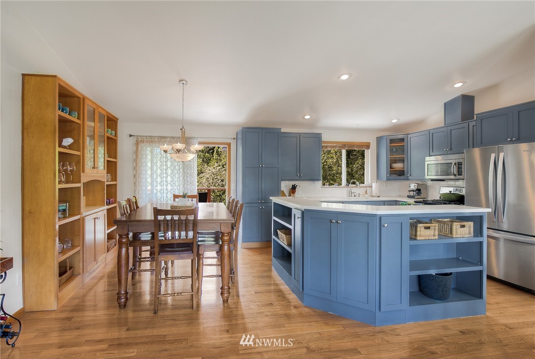 201 Morgan Road Everett, WA 98203 - Photo 12 of 29 a kitchen with stainless steel appliances wooden floors wooden cabinets dining table and chair
