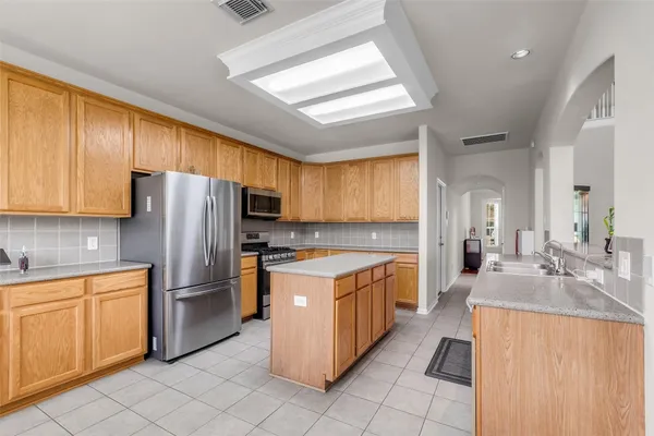 a kitchen with a stove a refrigerator and a sink