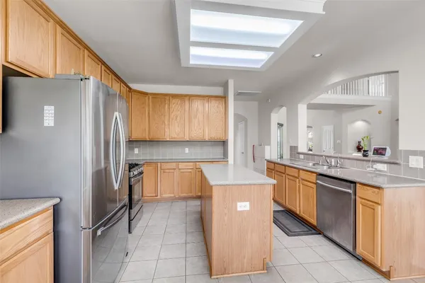 a kitchen with stainless steel appliances granite countertop a refrigerator and a sink