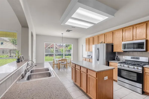 a kitchen with stainless steel appliances granite countertop a stove a refrigerator a sink and a stove
