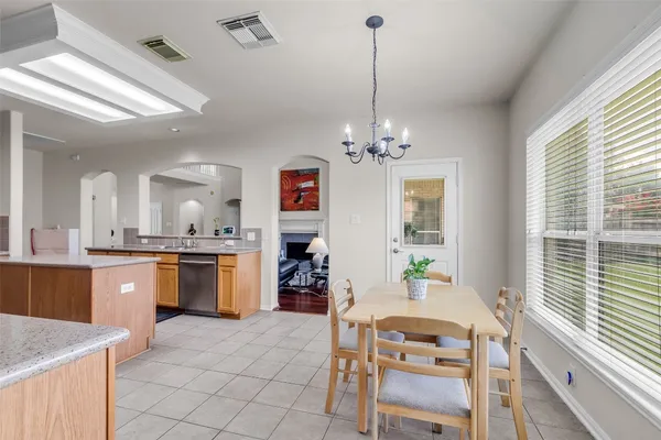 a kitchen with stainless steel appliances kitchen island granite countertop a stove a sink a dining table and chairs with wooden floor