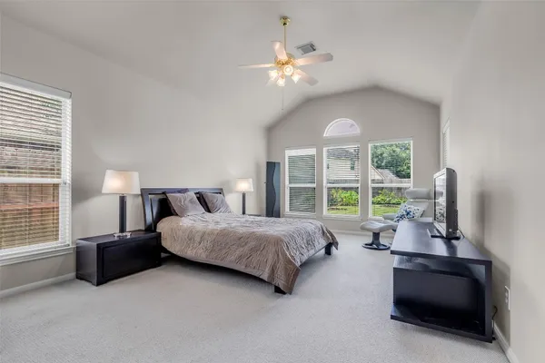 a spacious bedroom with a bed and a large window