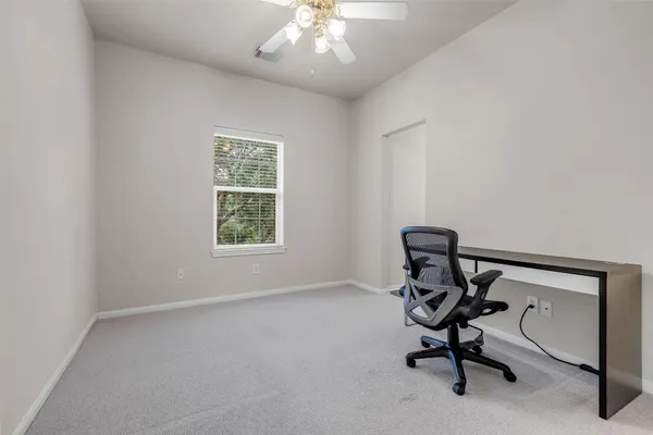 a view of a workspace with furniture and a window