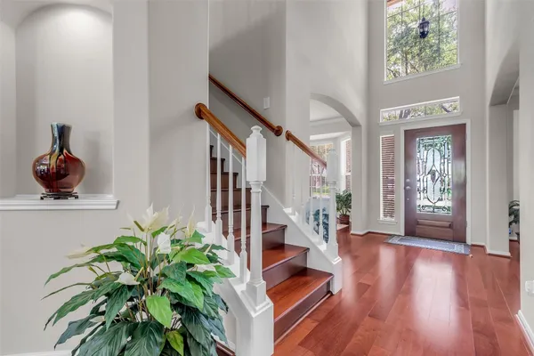 a living room with wooden floor and a potted plant
