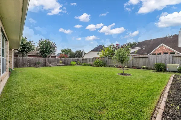 a view of an house with backyard and a tree