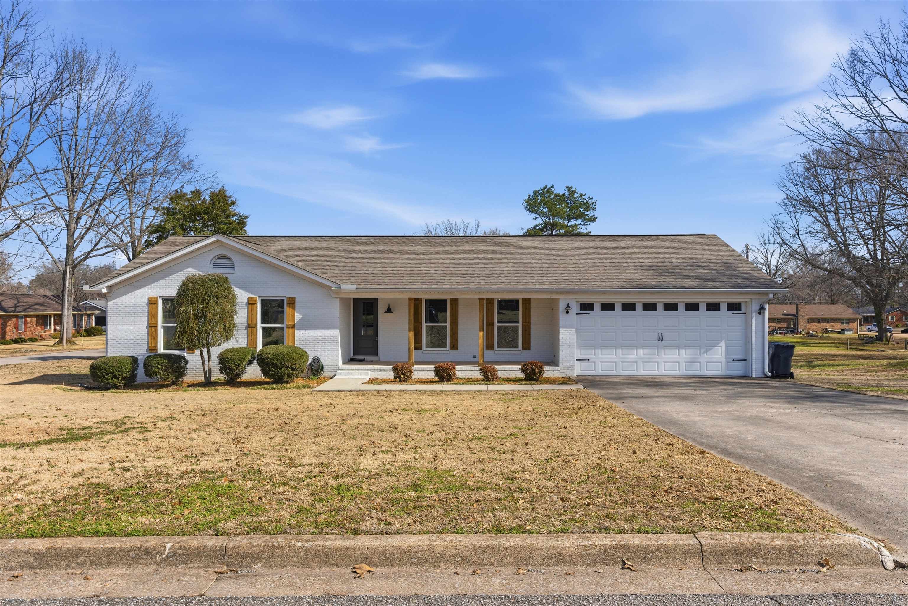 222 Barrett Street Bolivar, TN 38008 - Photo 1 of 30 Ranch-style house featuring covered porch, concrete driveway, a shingled roof, and a front lawn