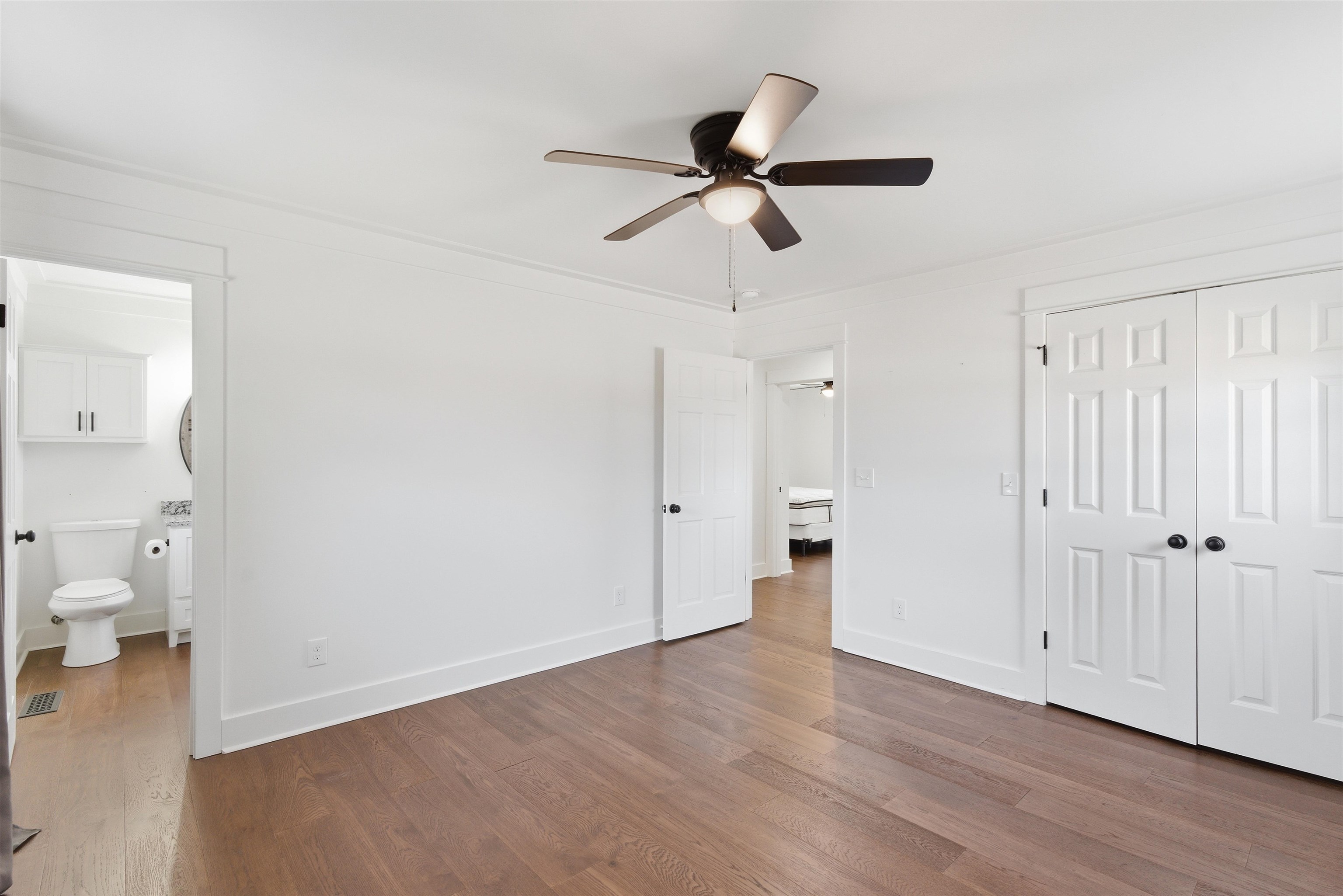 222 Barrett Street Bolivar, TN 38008 - Photo 14 of 30 Unfurnished bedroom featuring wood finished floors, a ceiling fan, a closet, and ensuite bathroom