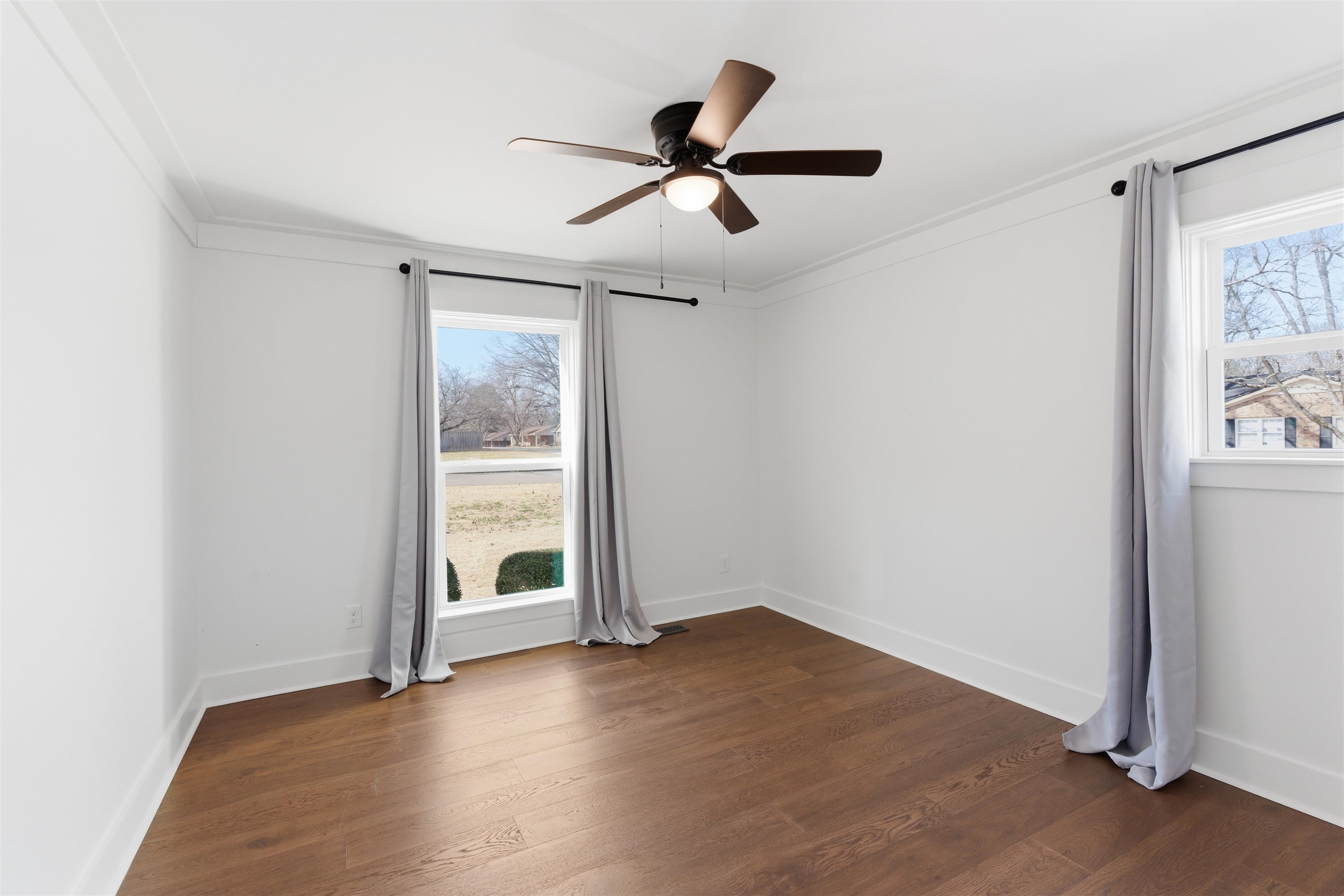 222 Barrett Street Bolivar, TN 38008 - Photo 17 of 30 Empty room featuring dark wood-style flooring, a ceiling fan, and crown molding