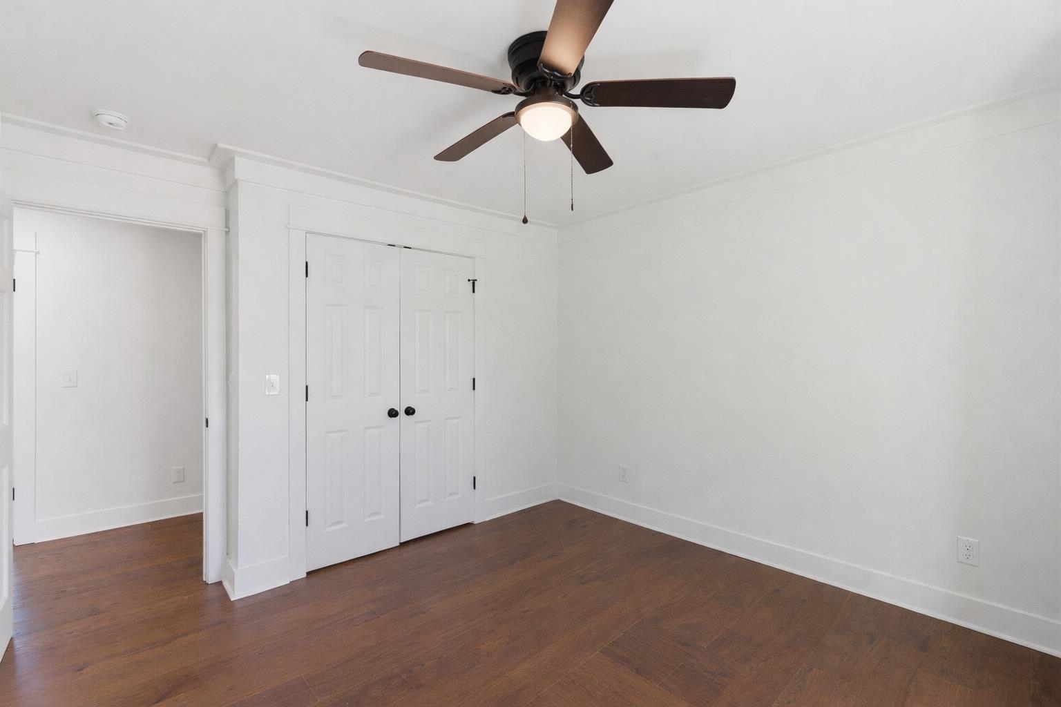 222 Barrett Street Bolivar, TN 38008 - Photo 21 of 30 Unfurnished bedroom featuring dark wood-style floors, a closet, and a ceiling fan