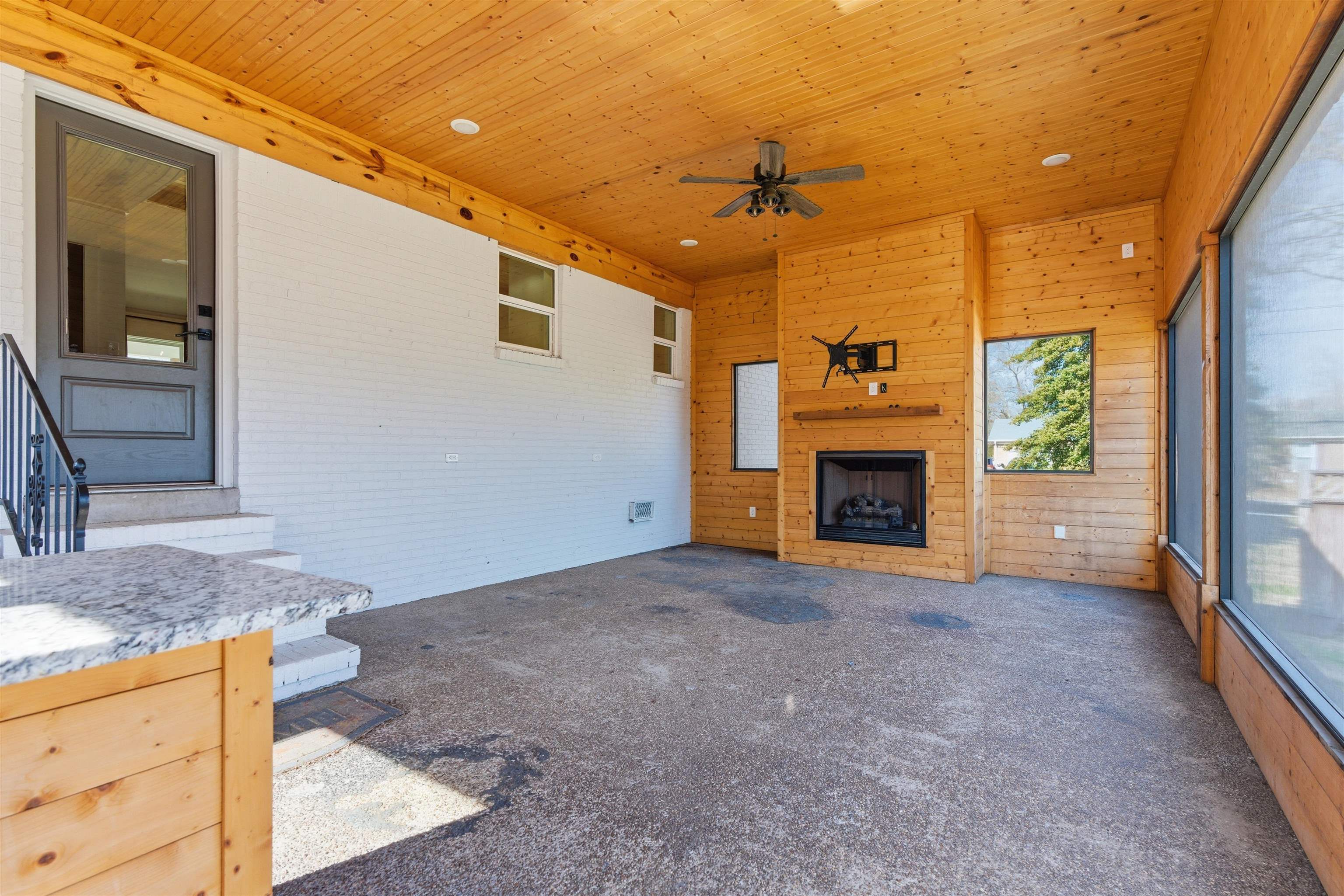 222 Barrett Street Bolivar, TN 38008 - Photo 22 of 30 Unfurnished living room featuring wooden walls, ceiling fan, carpet floors, a fireplace, and wooden ceiling
