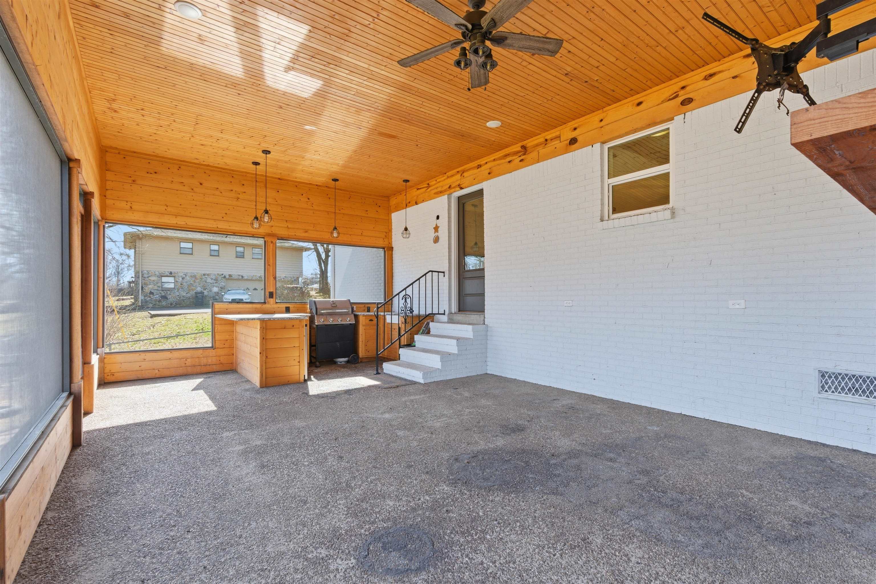 222 Barrett Street Bolivar, TN 38008 - Photo 23 of 30 Unfurnished living room with dark carpet, brick wall, wood ceiling, and a ceiling fan