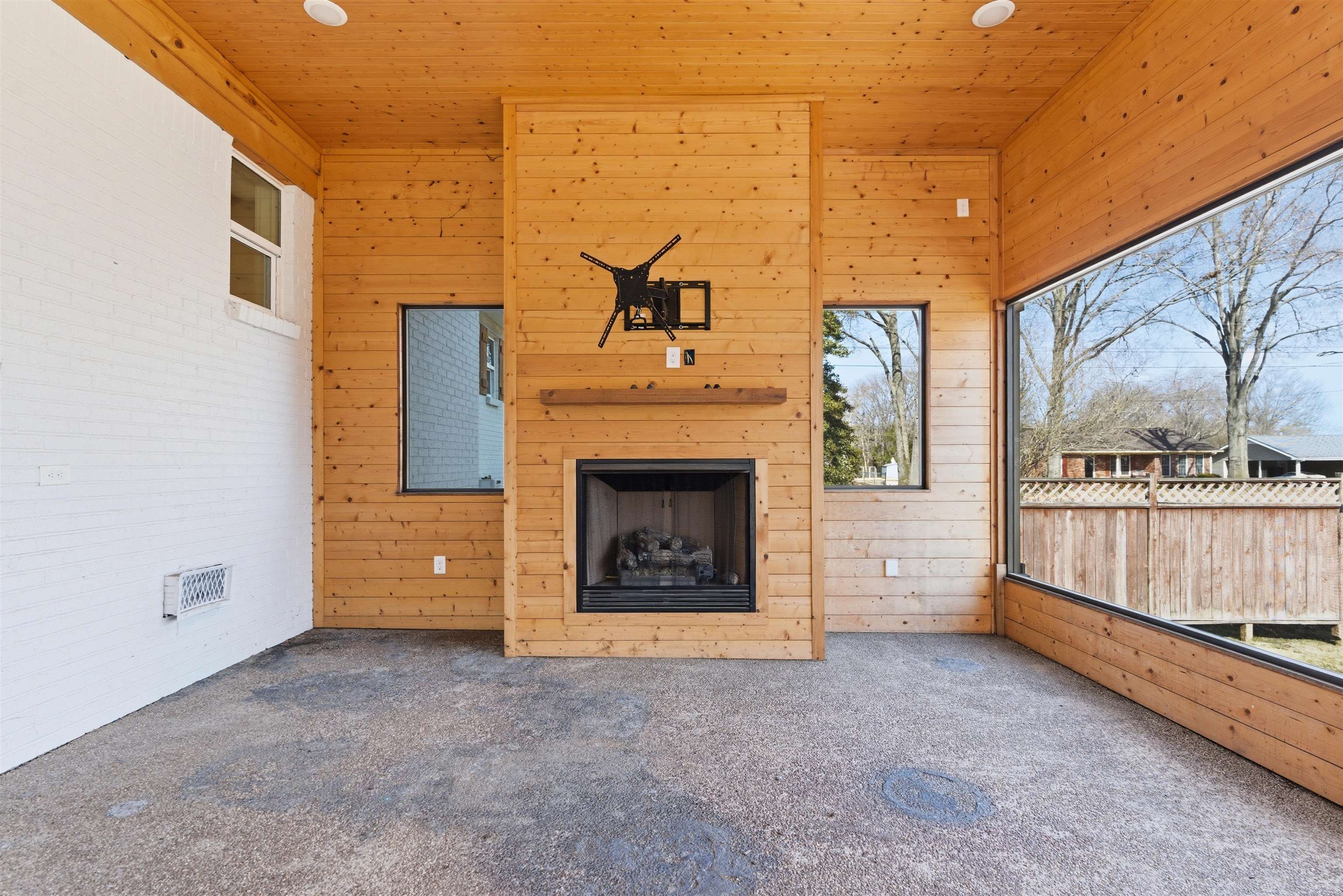 222 Barrett Street Bolivar, TN 38008 - Photo 24 of 30 Unfurnished living room with carpet floors, an outdoor fireplace, wood walls, and wood ceiling