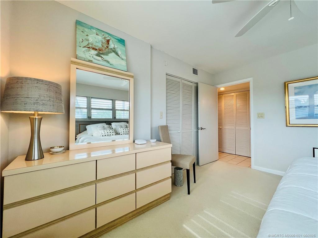 1550 Northeast Ocean Boulevard, Unit C204 Stuart, FL 34996 - Photo 42 of 54 a room with a bed and a mirror on dresser