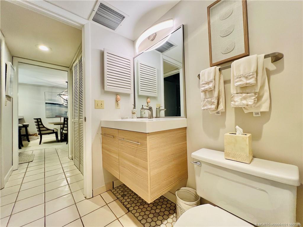 1550 Northeast Ocean Boulevard, Unit C204 Stuart, FL 34996 - Photo 47 of 54 a bathroom with a sink a toilet and a mirror