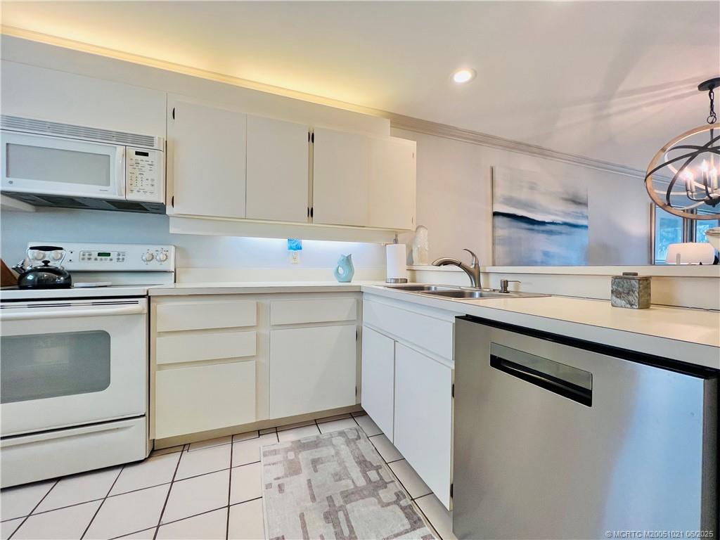 1550 Northeast Ocean Boulevard, Unit C204 Stuart, FL 34996 - Photo 5 of 54 a kitchen with a sink stove and cabinets