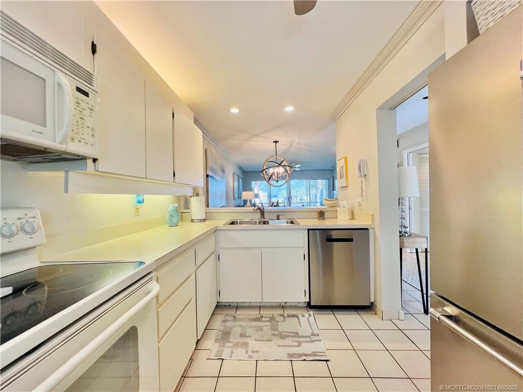 1550 Northeast Ocean Boulevard, Unit C204 Stuart, FL 34996 - Photo 8 of 54 a kitchen with white cabinets and white appliances