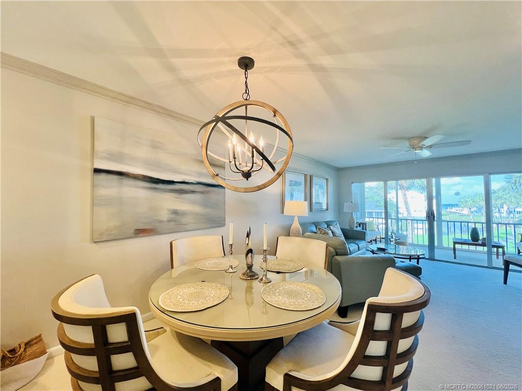 1550 Northeast Ocean Boulevard, Unit C204 Stuart, FL 34996 - Photo 10 of 54 a dining room with furniture a large window and a chandelier