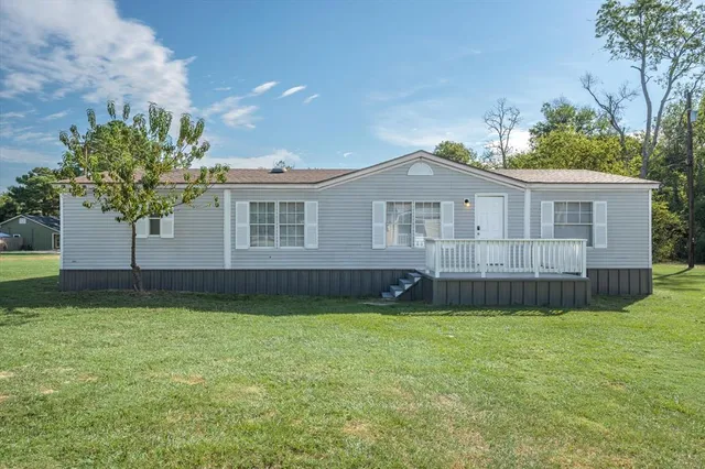 a view of a house with a yard and sitting area