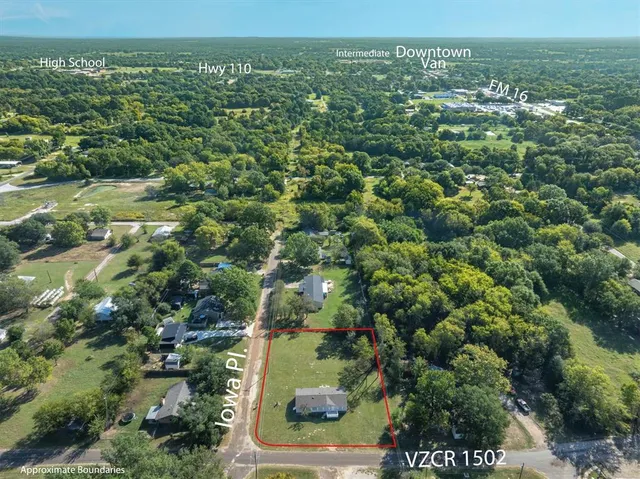 an aerial view of residential houses with outdoor space and trees