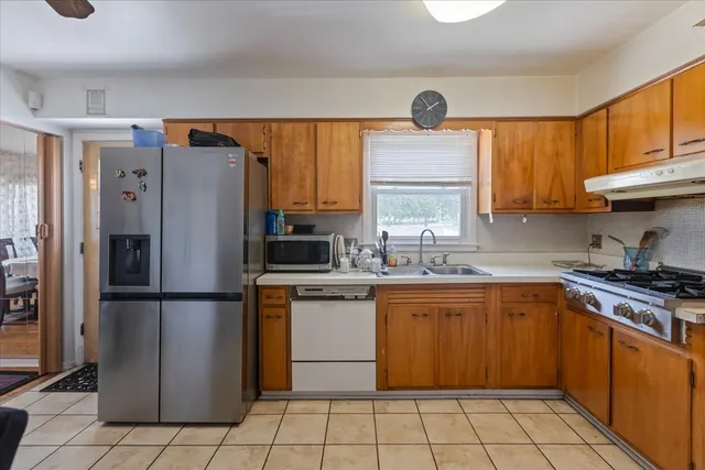 a kitchen with a refrigerator a sink cabinets and a window