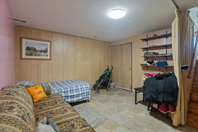 a bedroom with a bed and large windows