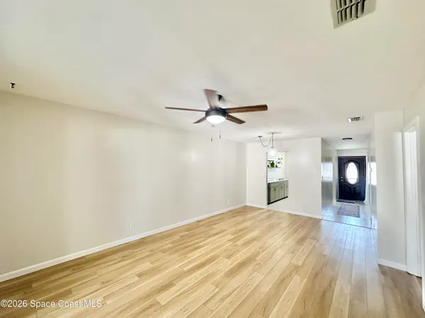 a view of a big room with wooden floor and a ceiling fan