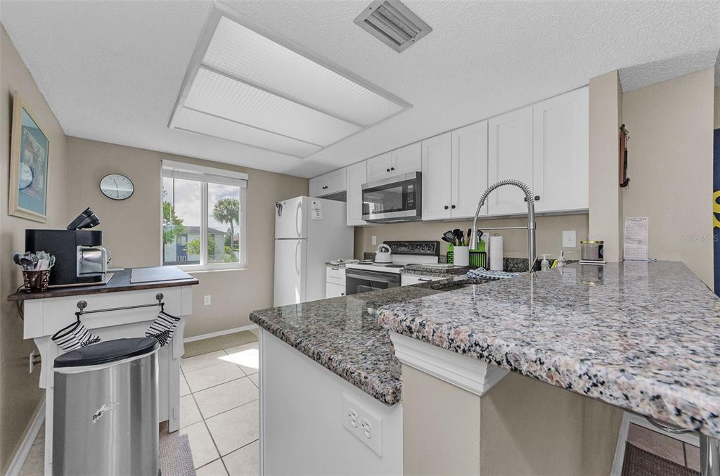 146 Cypress Lane Oldsmar, FL 34677 - Photo 12 of 44 a kitchen with stainless steel appliances granite countertop a sink stove and refrigerator