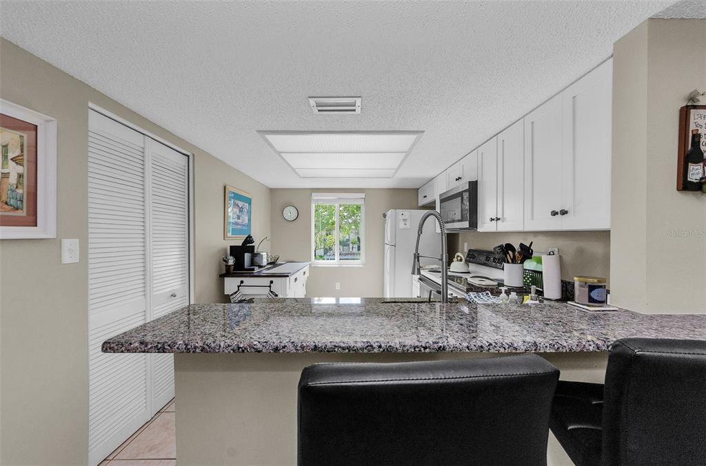 146 Cypress Lane Oldsmar, FL 34677 - Photo 13 of 44 a kitchen with granite countertop kitchen island a sink stove and cabinets