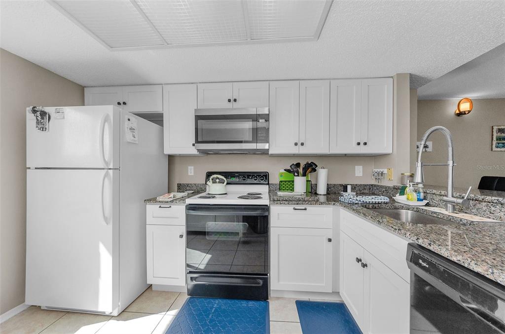 146 Cypress Lane Oldsmar, FL 34677 - Photo 15 of 44 a kitchen with stainless steel appliances granite countertop a refrigerator stove a sink and white cabinets