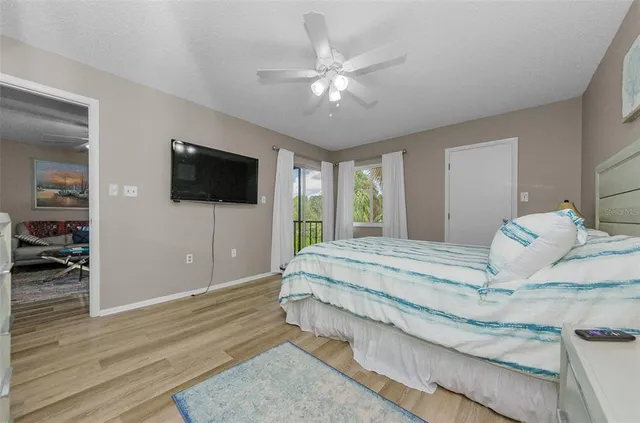 a spacious bedroom with a bed and a flat screen tv