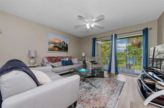 a living room with furniture two window and a flat screen tv