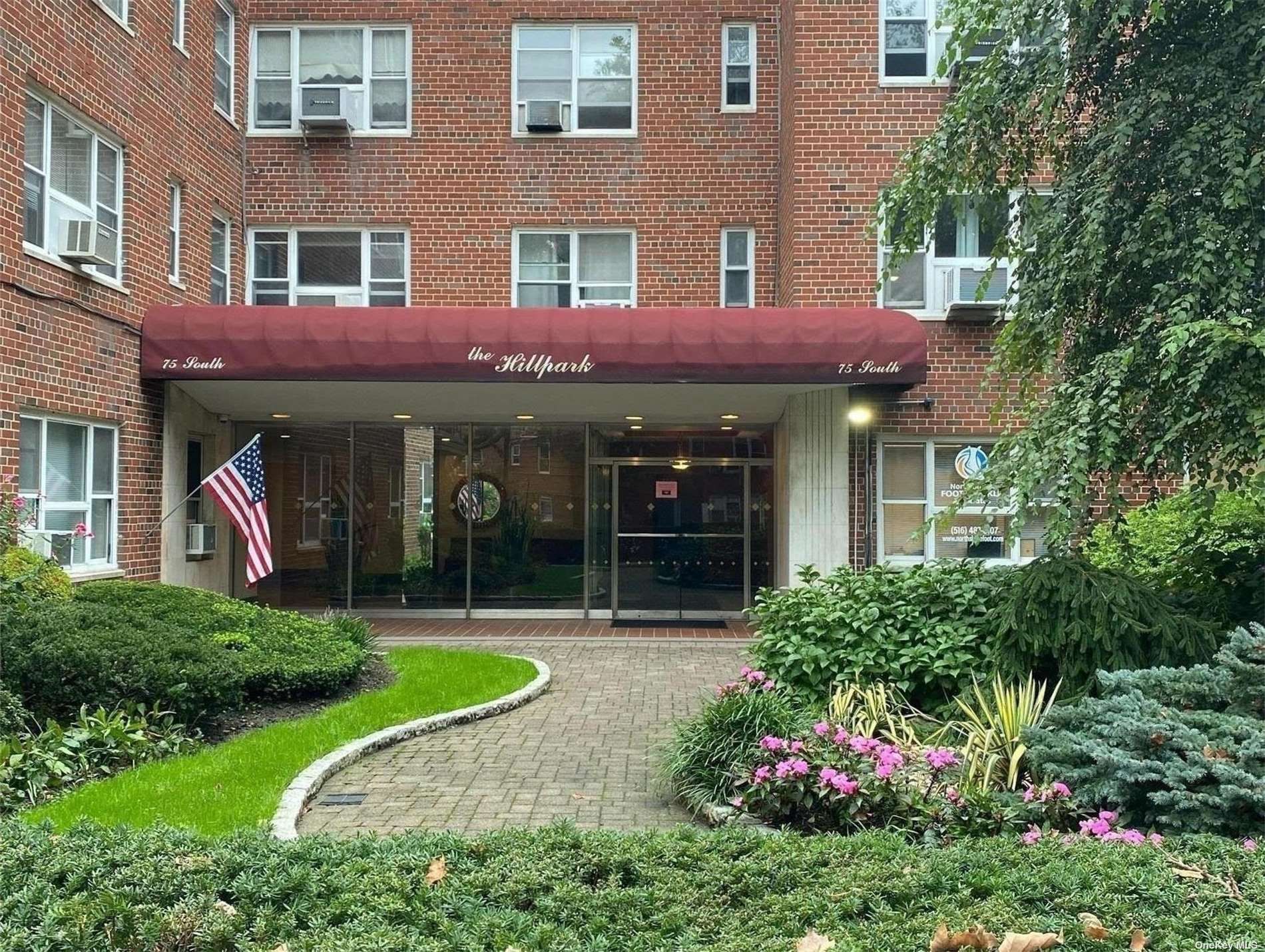 75 South Middle Neck Road, Unit 2J Great Neck, NY 11021 - Photo 1 of 1 a view of a brick building with a yard and plants