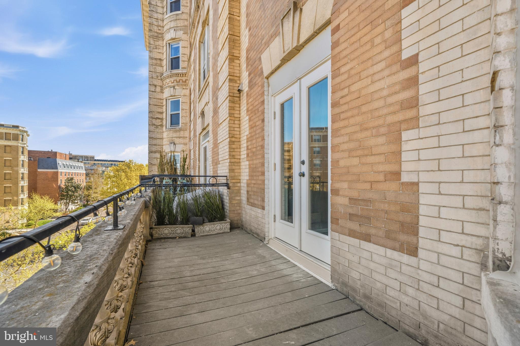 1851 Columbia Road Northwest, Unit 401 Washington, DC 20009 - Photo 21 of 27 a view of a balcony with wooden floor and stairs