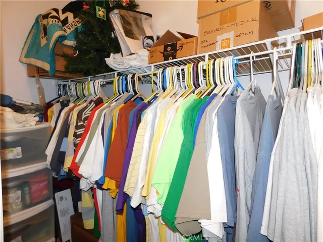 a view of walk in closet with clothes and shoes