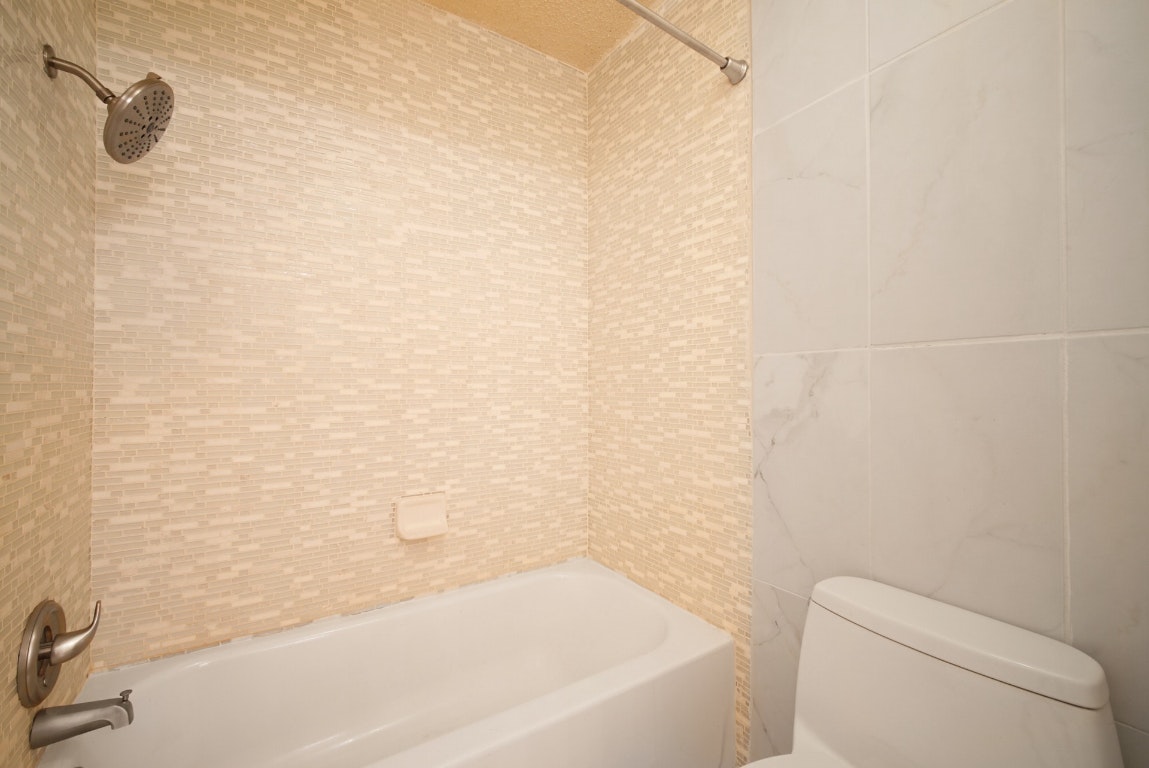 10509 Doering Lane Austin, TX 78750 - Photo 13 of 36 a bathroom with a bathtub and toilet