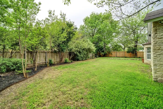 a view of a backyard with a garden and trees