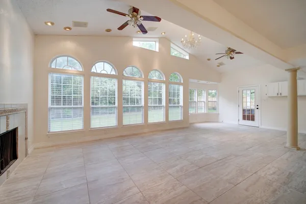 a view of an empty room with a fireplace and a large window