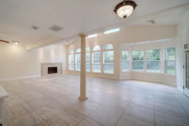 a view of an empty room with a fireplace and a window