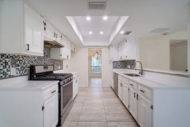 a kitchen with stainless steel appliances a sink stove and cabinets