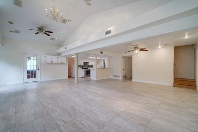 a view of a livingroom with a furniture chandelier fan and refrigerator