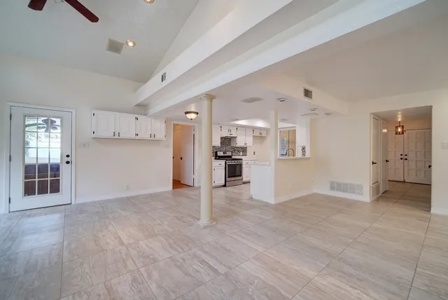 a view of a kitchen with refrigerator and white cabinets