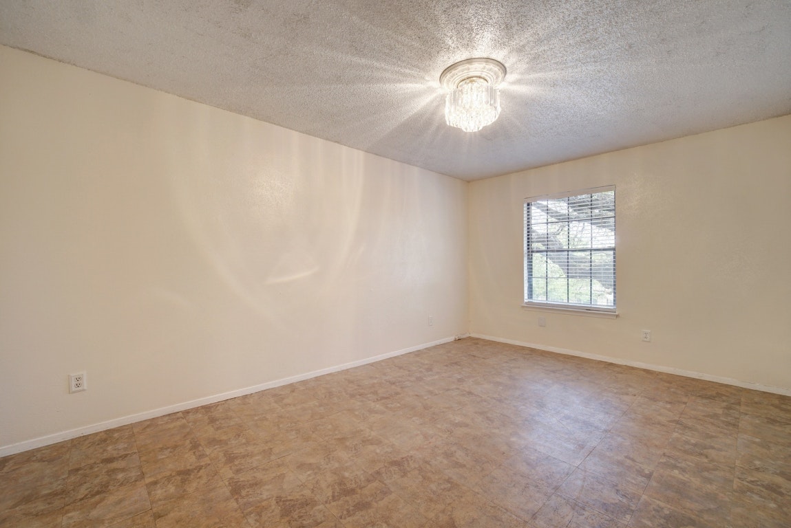 10509 Doering Lane Austin, TX 78750 - Photo 9 of 36 an empty room with a chandelier fan and windows