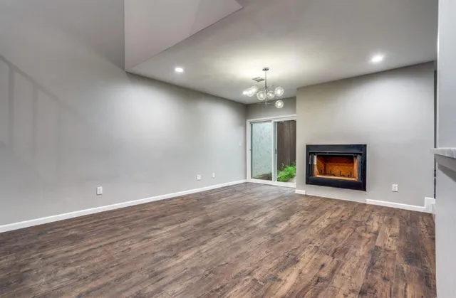 an empty room with stairs and wooden floor