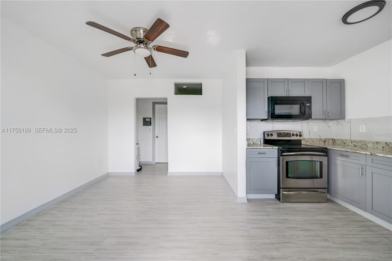 1281 Northwest 61st Street, Unit 2 Miami, FL 33142 - Photo 3 of 13 a kitchen with a stove and a microwave