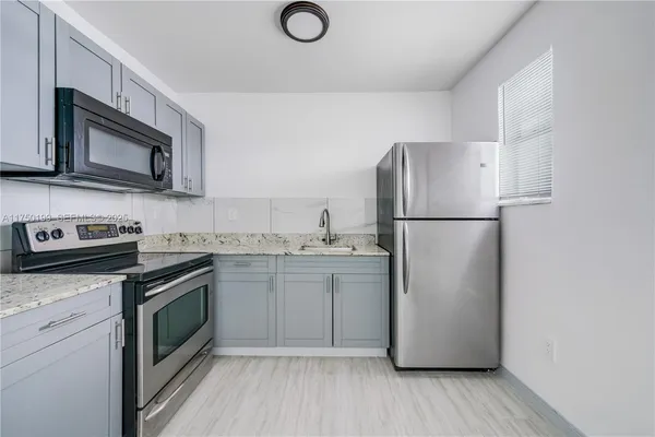 a kitchen with a sink stove and refrigerator