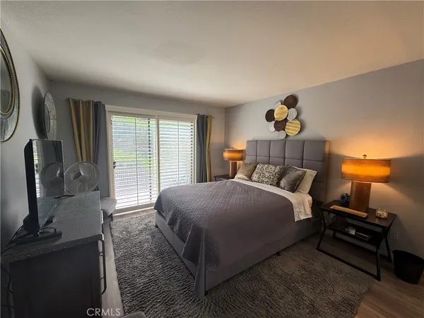 a bedroom with a bed a dresser with mirror