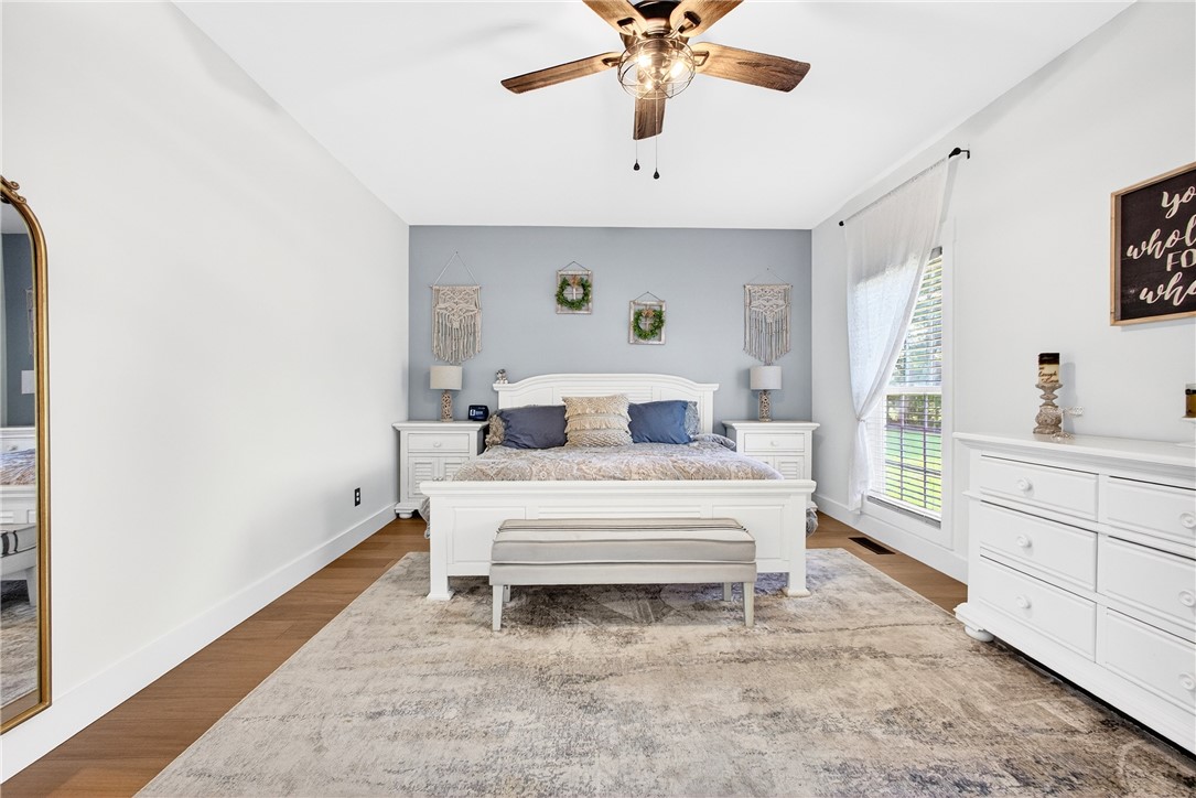5016 Copeland Road Belton, SC 29627 - Photo 16 of 45 Well-lit primary bedroom features rich wood flooring and a refreshing ceiling fan.