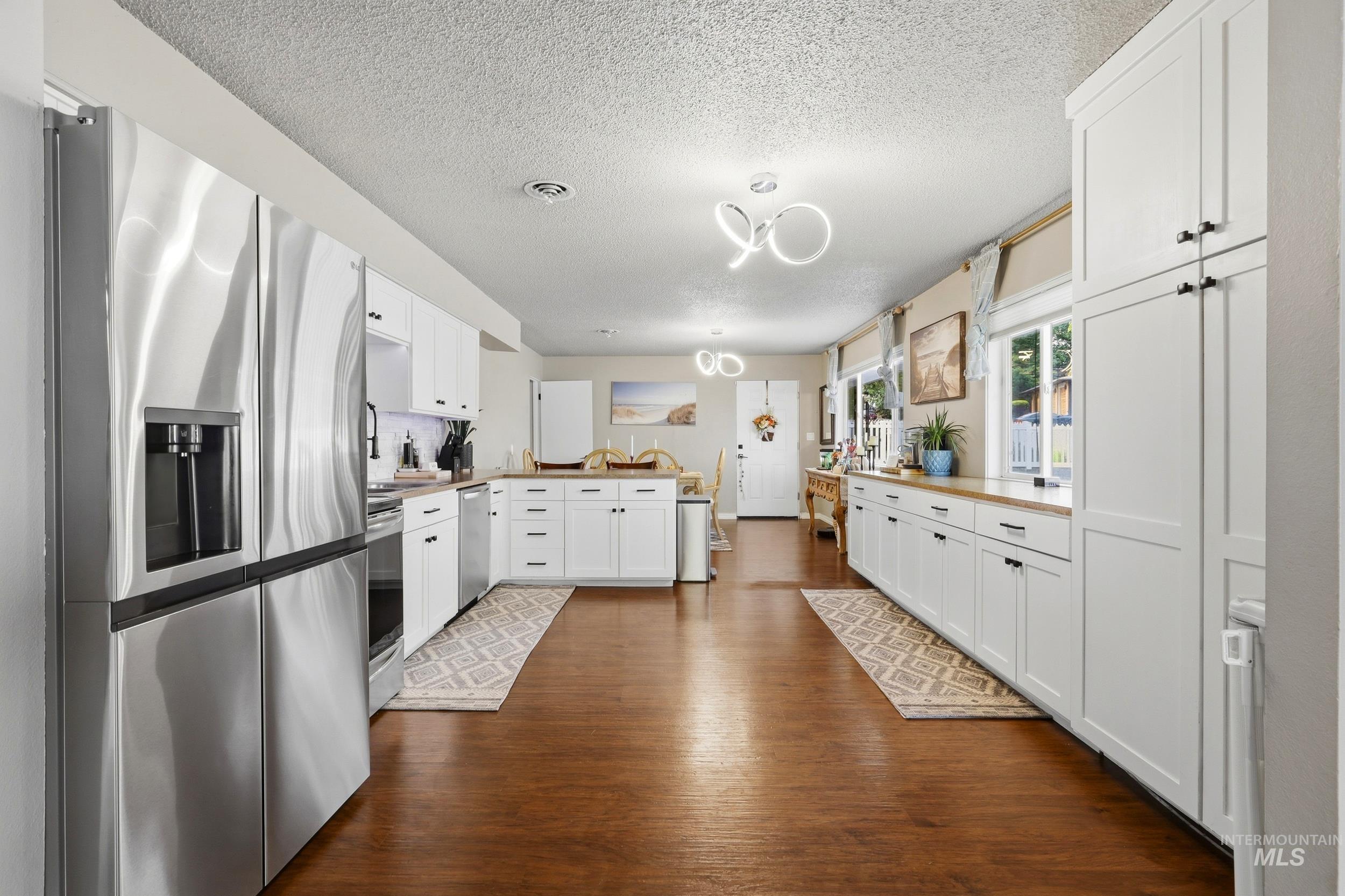 1803 14th Street Lewiston, ID 83501 - Photo 8 of 27 Expansive kitchen featuring stainless steel appliances, wood-finish flooring, white cabinetry, wood countertops, and modern light fixtures